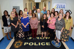 A group of people standing in front of a police sign.