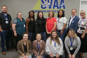 A group of people posing for a picture in front of the svaia logo.