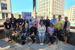A group of people sitting on chairs in front of a building.