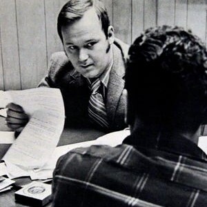 A man sitting at a table with another man.