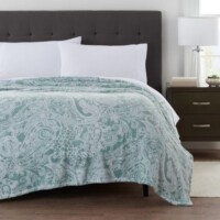 A bed with a white and blue blanket on it